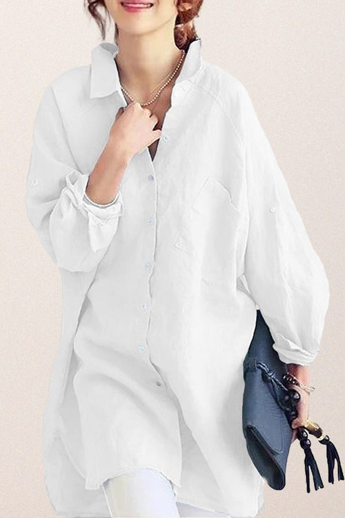 White oversized linen shirt with relaxed fit and button-down front, styled casually with rolled-up sleeves and a collar.