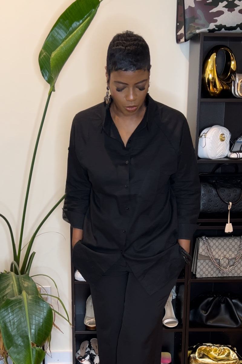 Black oversized linen shirt with relaxed fit and long sleeves worn by woman indoors