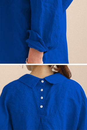 Close-up of blue oversized linen shirt with rolled sleeves and back button detailing showcasing breathable cotton-linen fabric and relaxed fit