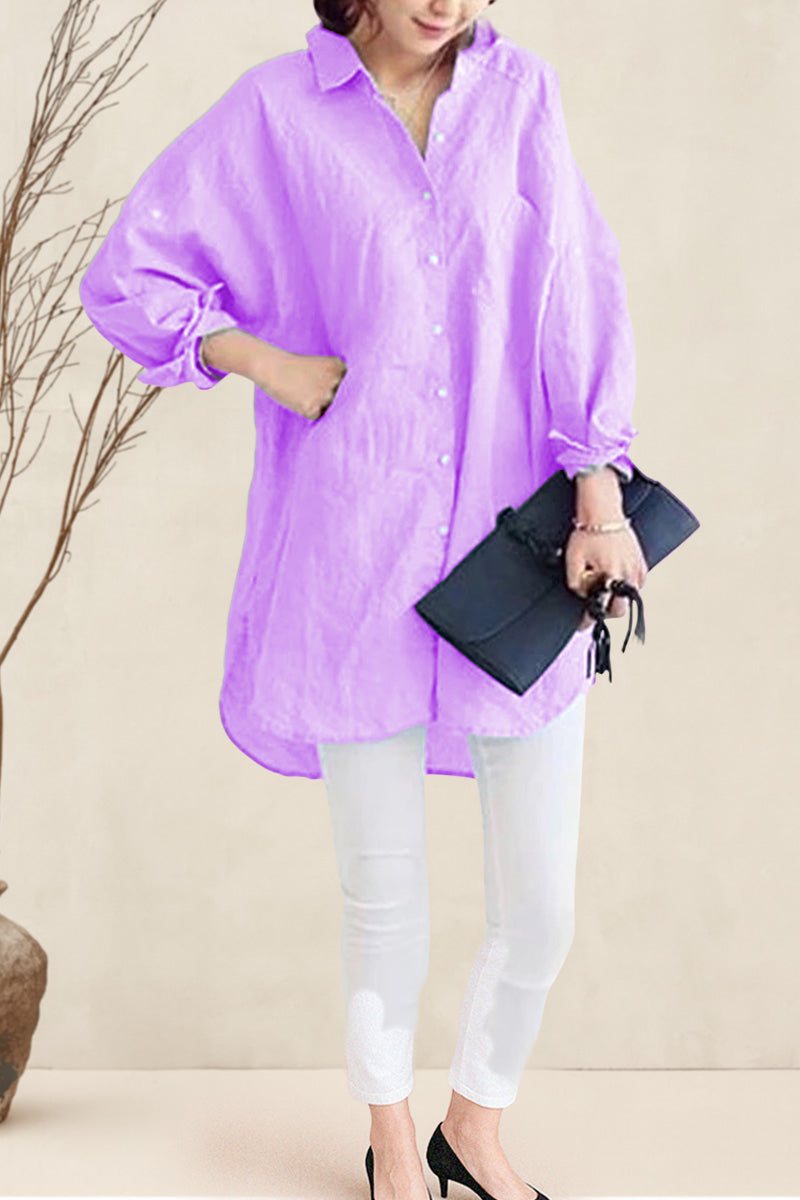 Woman wearing oversized linen shirt in light purple with white pants and black clutch bag