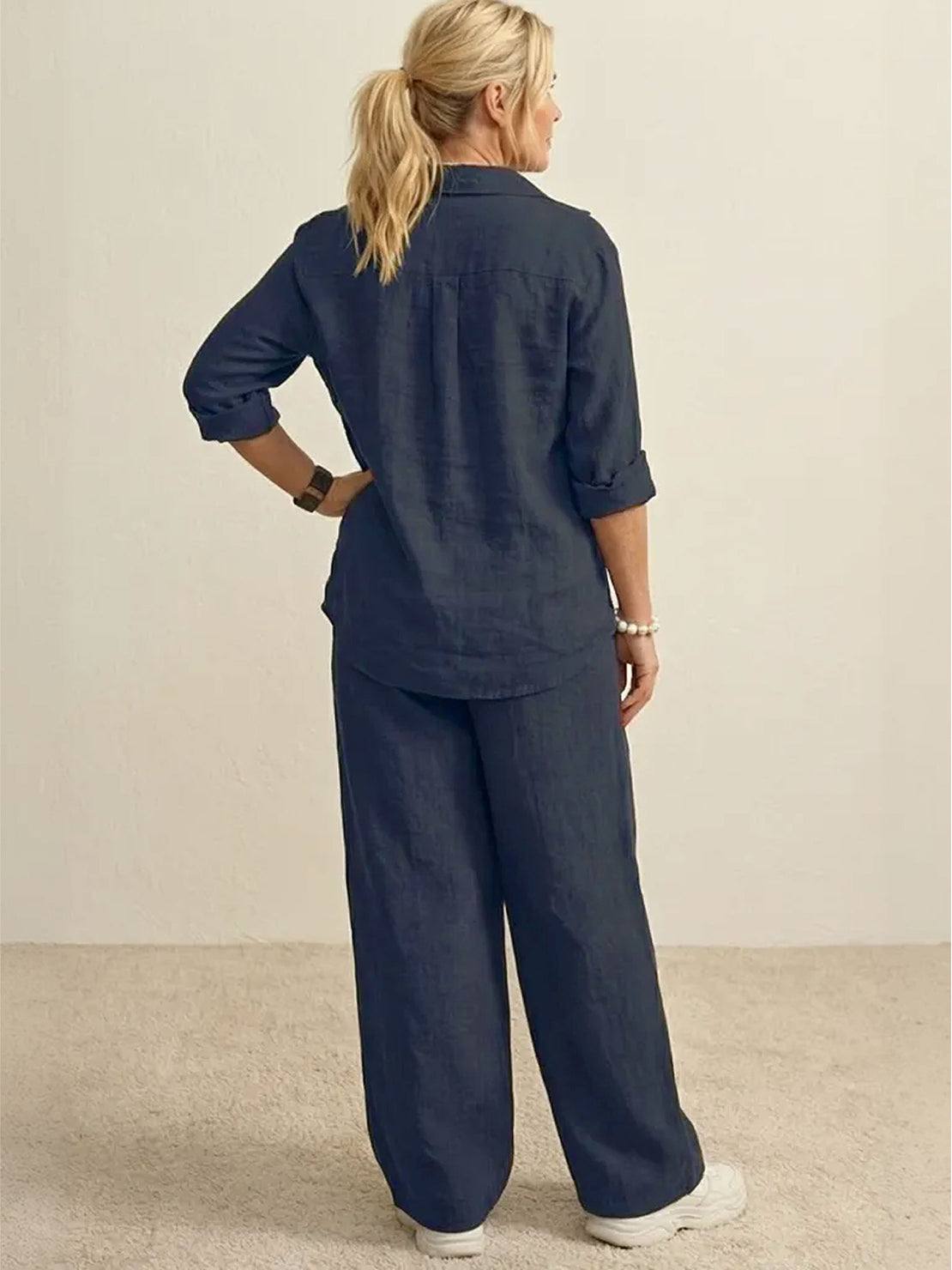 Back view of a woman wearing a navy oversized 100% cotton shirt and wide-leg pants co-ord set with rolled-up sleeves and relaxed fit