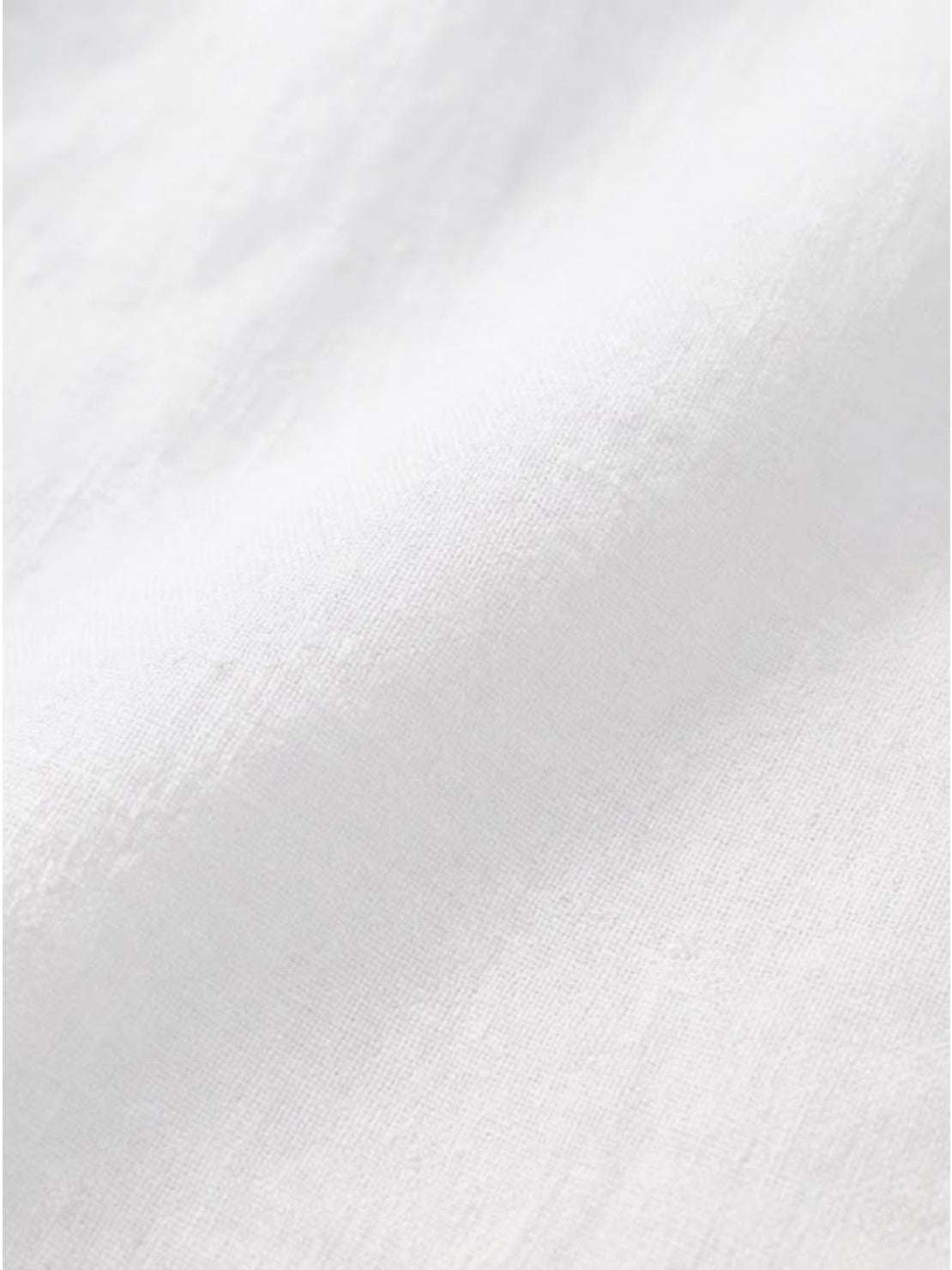 White pure linen age-defying shirt with elegant button detail on a wooden hanger