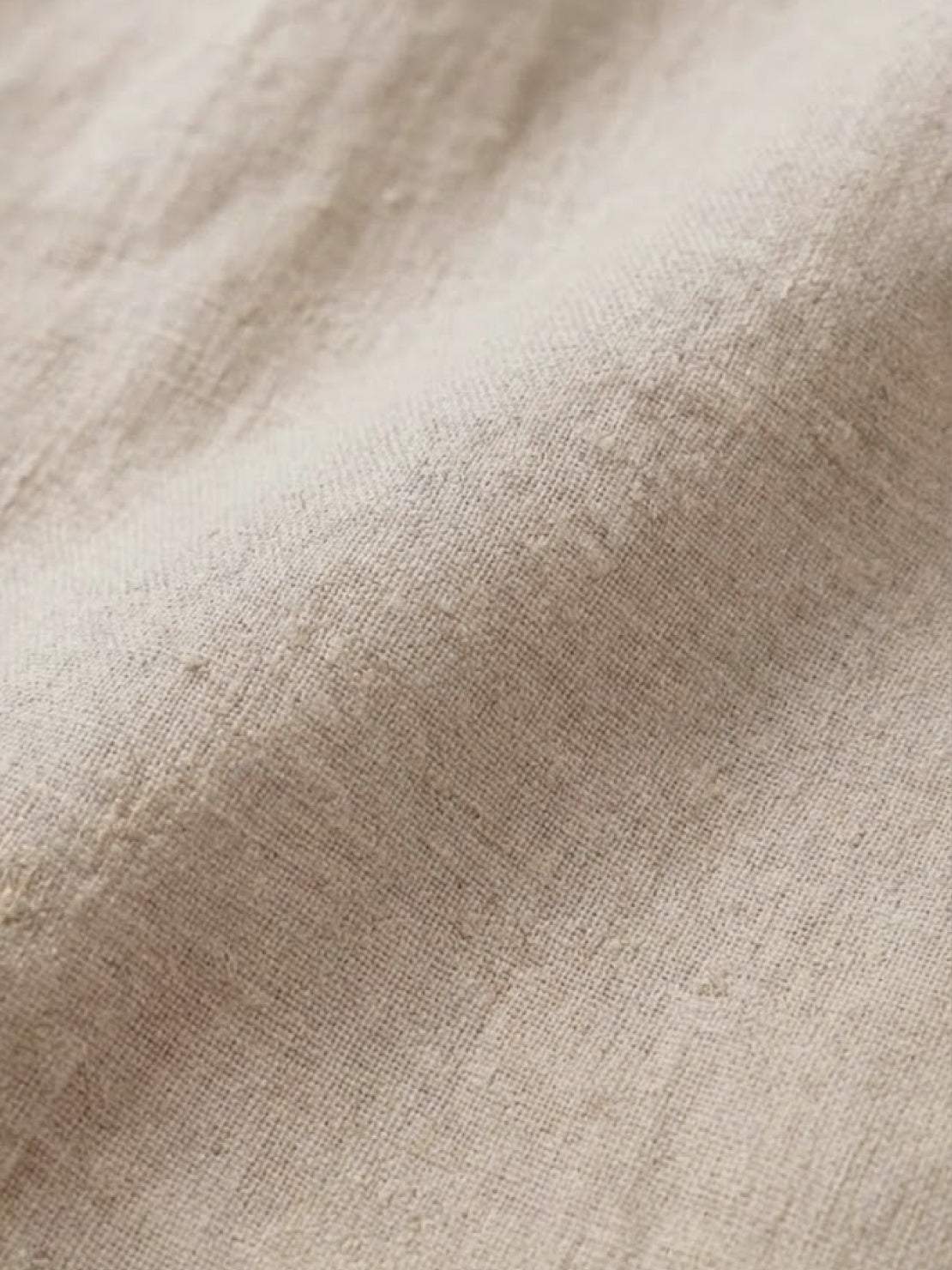 Close-up of soft beige pure linen fabric texture for age-defying shirt