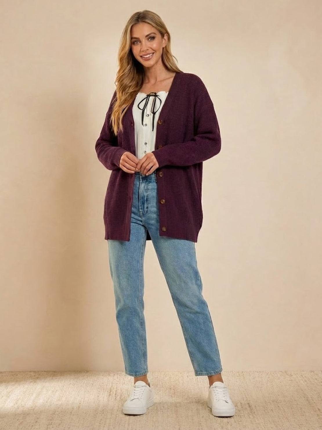 Relaxed fit oversized button down knitwear cardigan in deep plum on woman with casual jeans and white sneakers