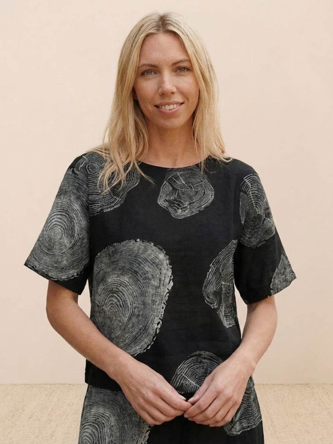 Woman wearing a black wide short sleeve loose fit co-ord top with gray circular patterns, part of the Loose Fit Co-ord Set
