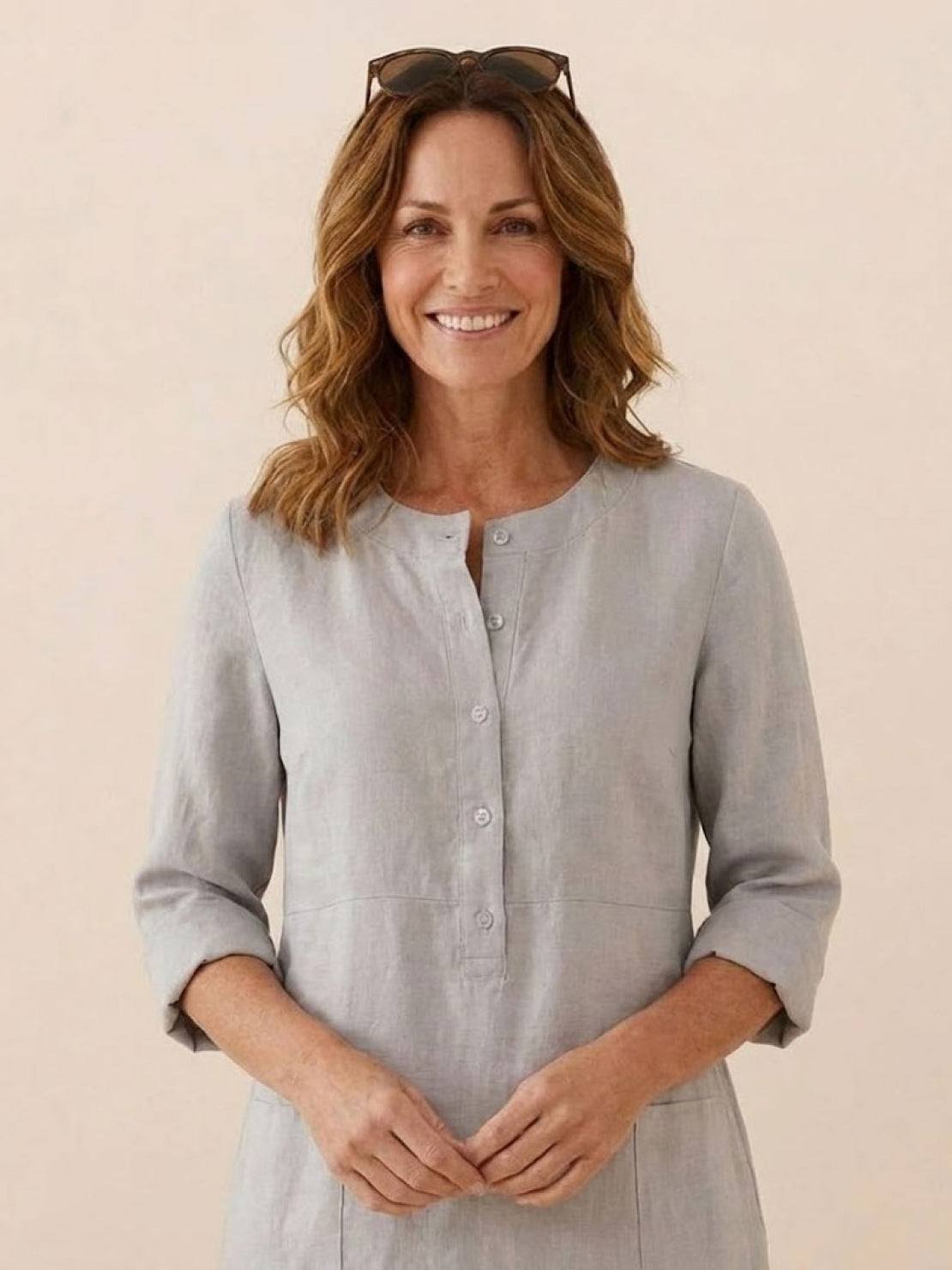 Woman wearing light gray cotton dress with rolled ¾ sleeves and button front