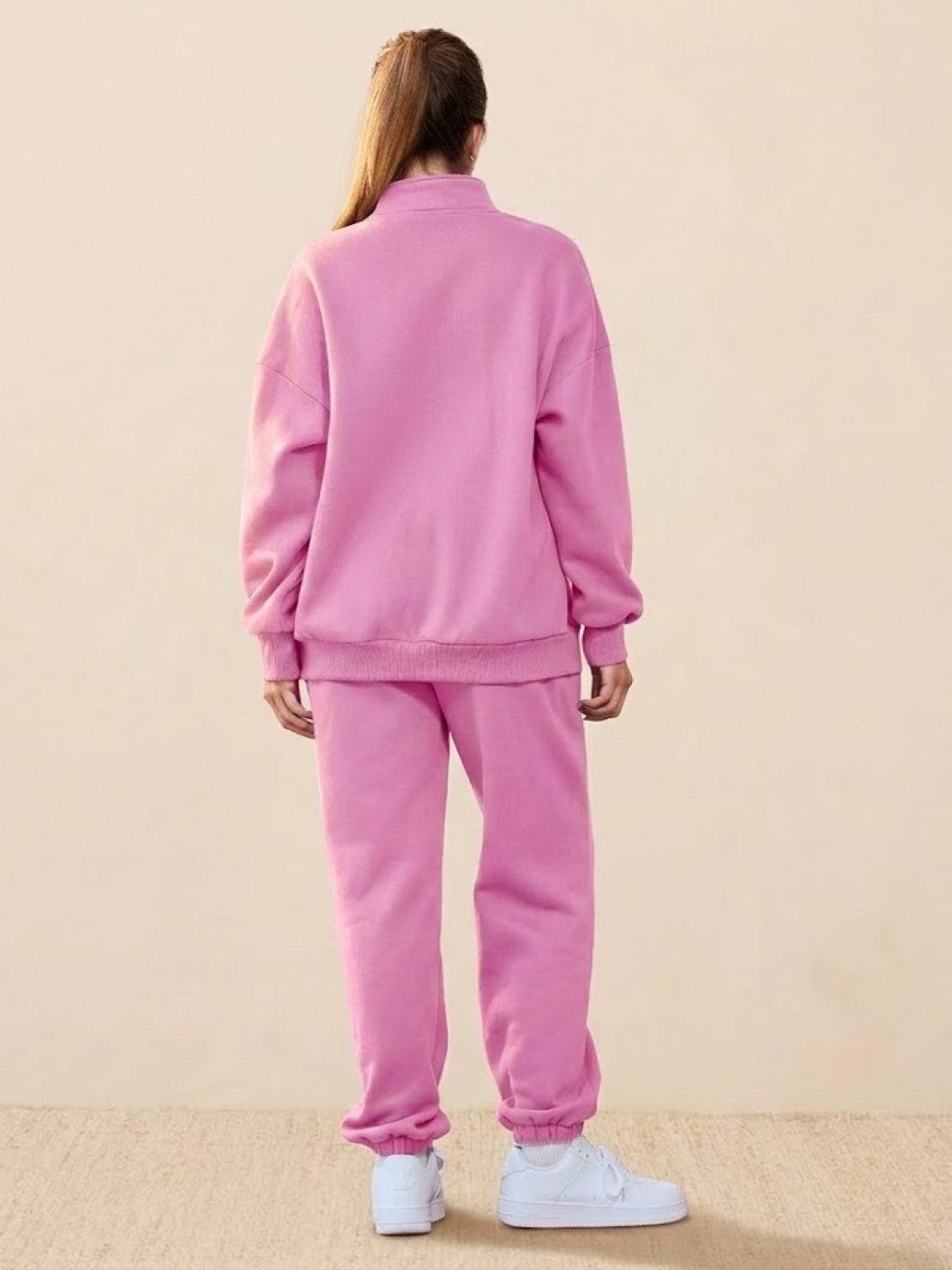 Woman wearing pink ultra-soft and comfy co-ord tracksuit set with white sneakers, back view