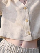 Lightweight 100% linen French top with V-neck, short sleeves, three-button front, and relaxed boxy fit in light khaki and off white colors