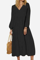 Woman wearing black midi long sleeve spring dress with V-neck and loose fit, holding woven handbag