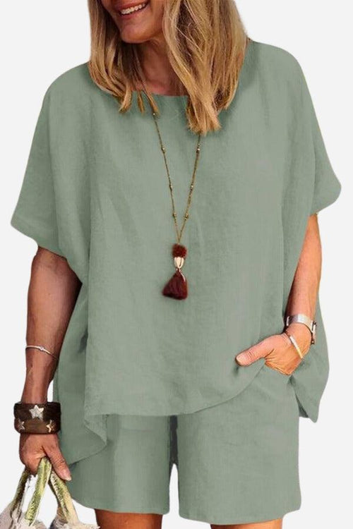 Woman wearing comfy linen-like shirt and shorts two-piece set in light green with casual accessories