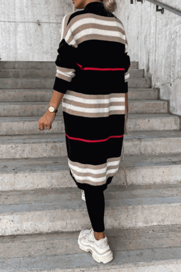 Cozy striped long knitted cardigan with oversized fit and soft fabric, black, beige, and red stripes, worn with black leggings and white sneakers.