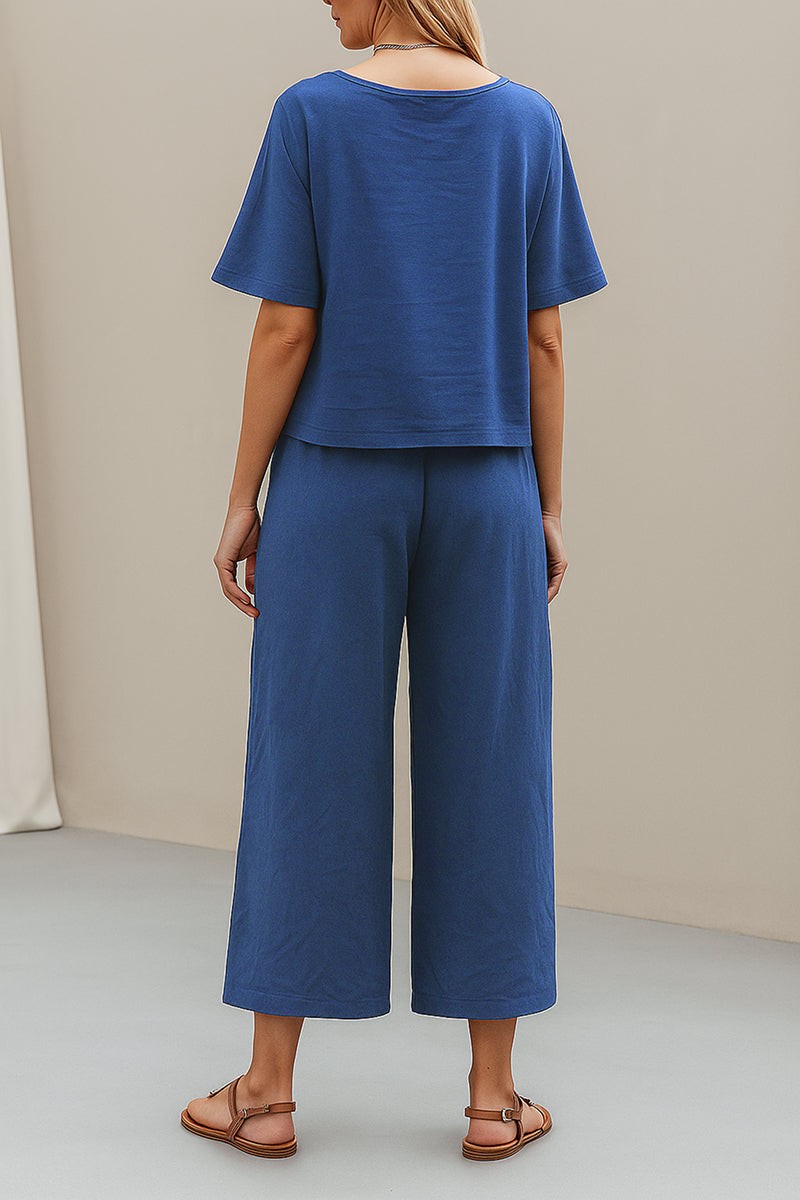 Rear view of model wearing blue loose fit co-ord set with wide-leg trousers and short sleeve top