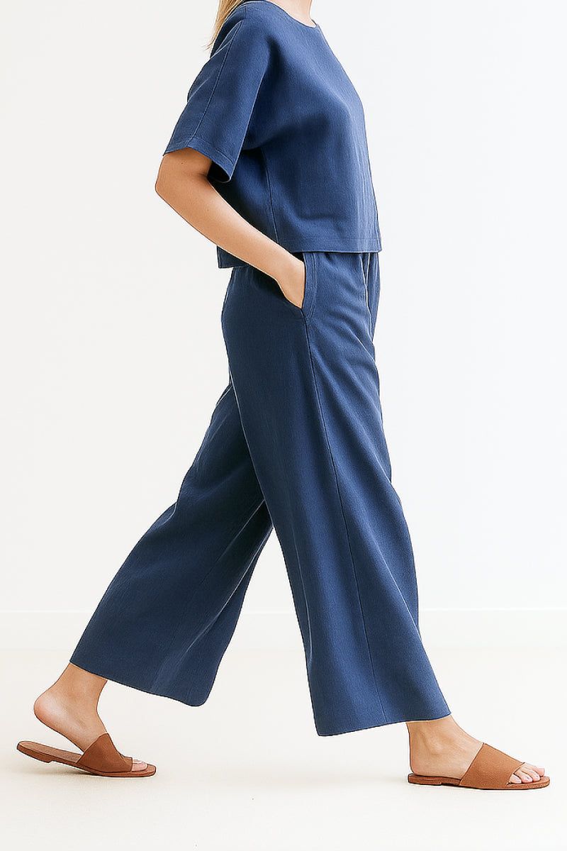 Woman wearing navy blue loose fit co-ord set with short sleeves and wide-leg pants paired with brown sandals