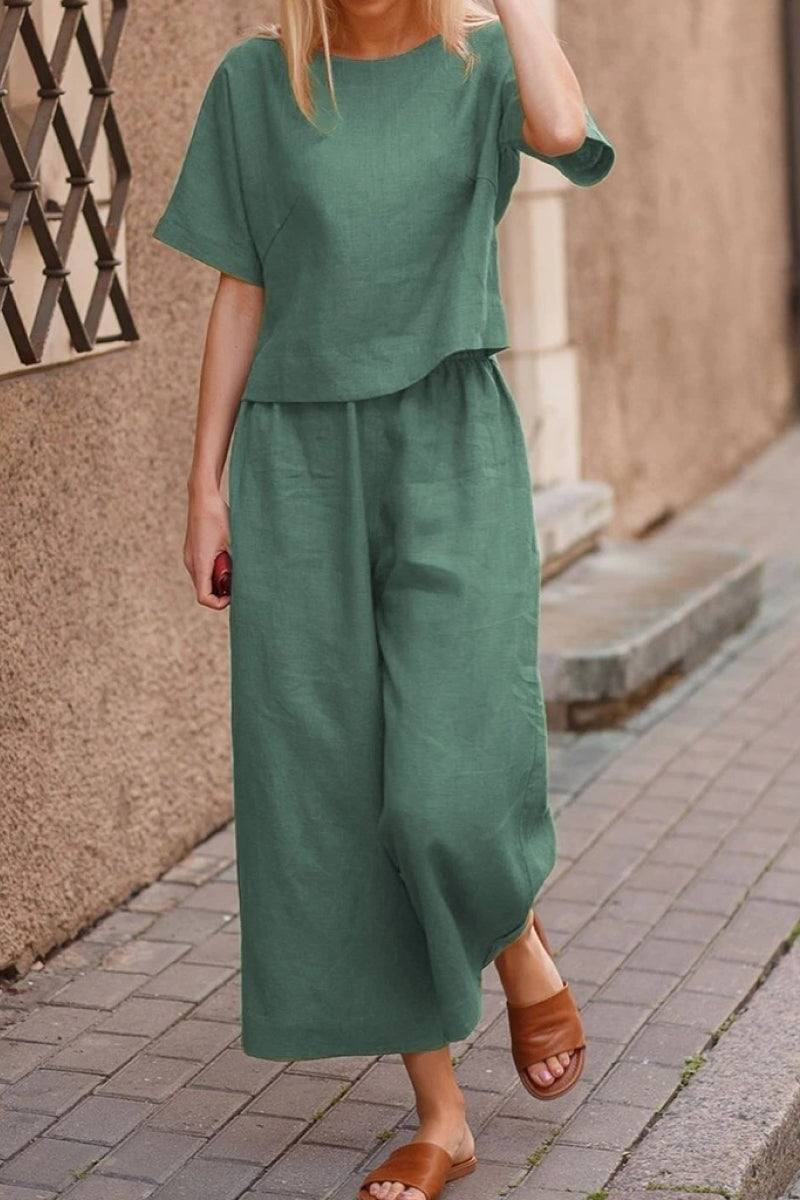 Woman wearing green loose fit co-ord set with wide-leg pants and short-sleeve top walking on street