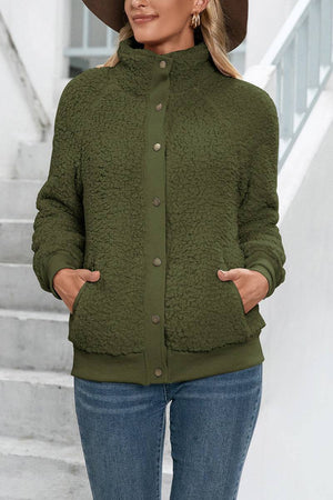woman wearing cozy long sleeve button sherpa jacket in olive green with pockets outdoors