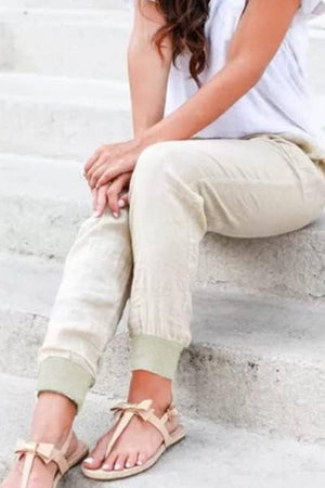 Woman wearing relaxed chic elastic ankles pants sitting on stairs in casual outfit
