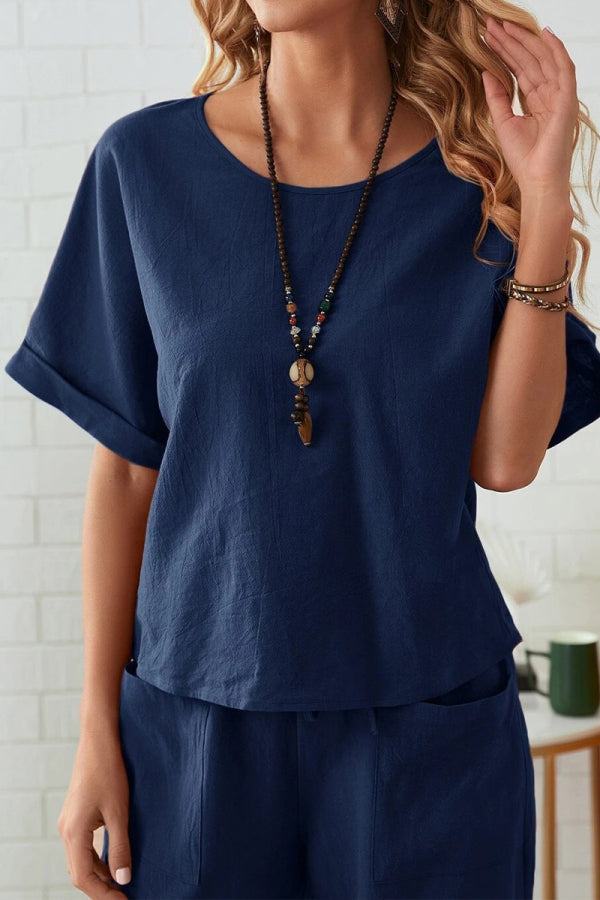 Woman wearing navy rolled cuff top with relaxed fit and matching patch pocket pants set