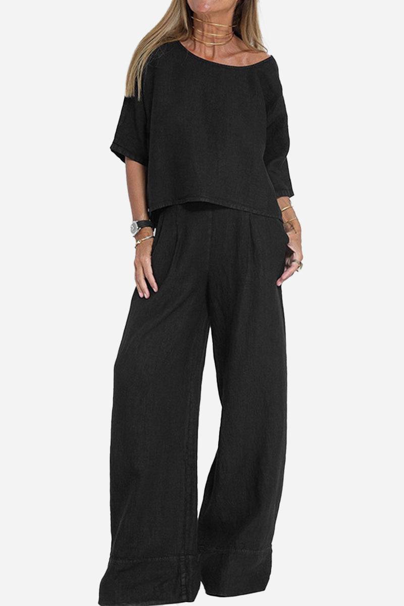 Woman wearing black short-sleeved pullover and wide trouser matching set in cotton fabric with relaxed fit.