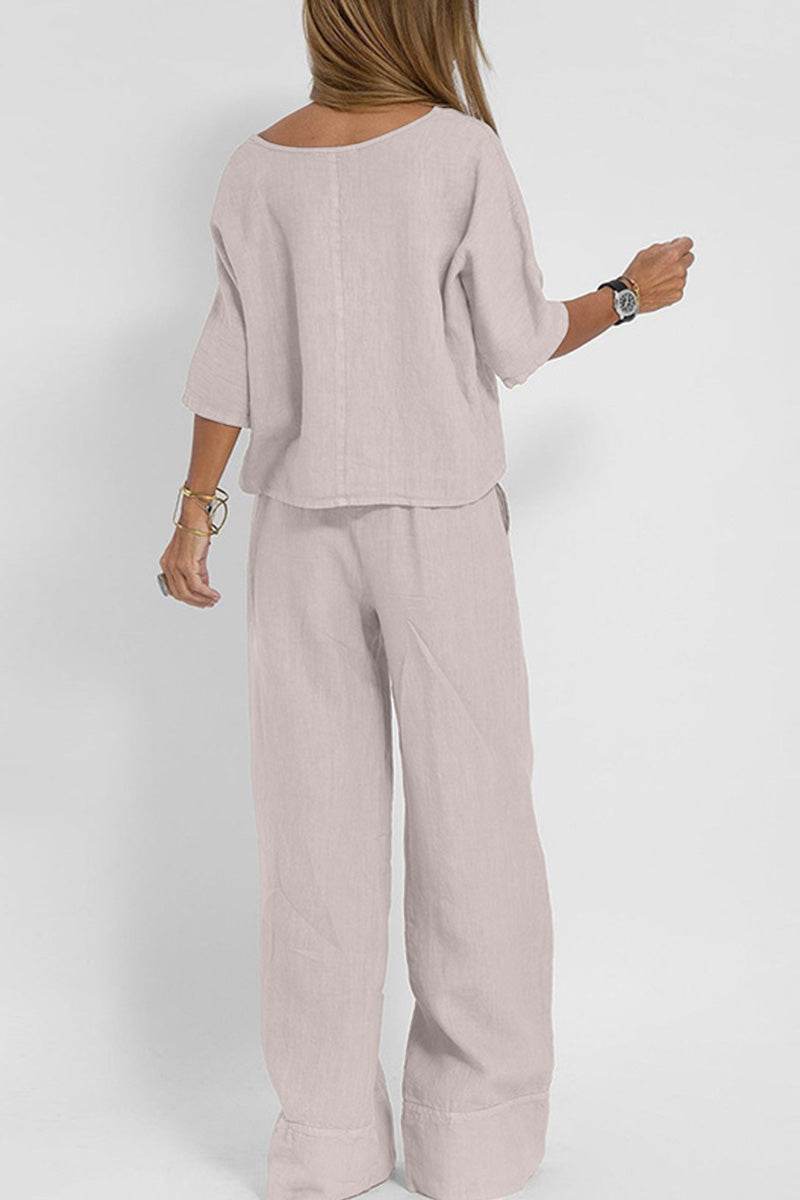 Woman wearing light-colored short-sleeved pullover and wide trouser matching set from behind