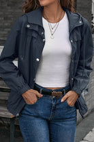 woman wearing navy blue outdoor hooded raincoat and windbreaker with white T-shirt and jeans