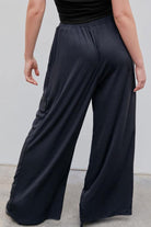 Back view of black stretchy wide-leg pants with elastic waistband for all-day comfort and flattering silhouette
