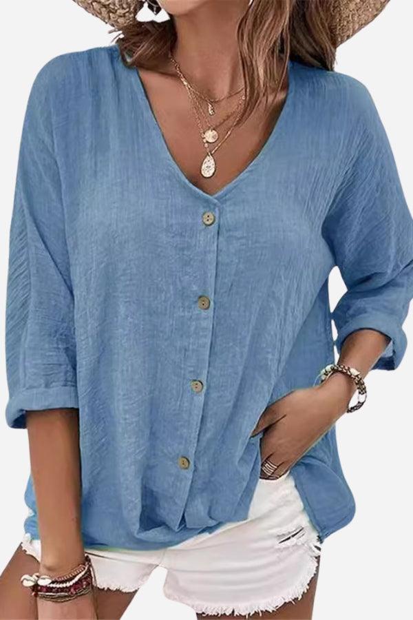 Blue button front tunic with V-neck and rolled sleeves, paired with white shorts and layered necklaces.