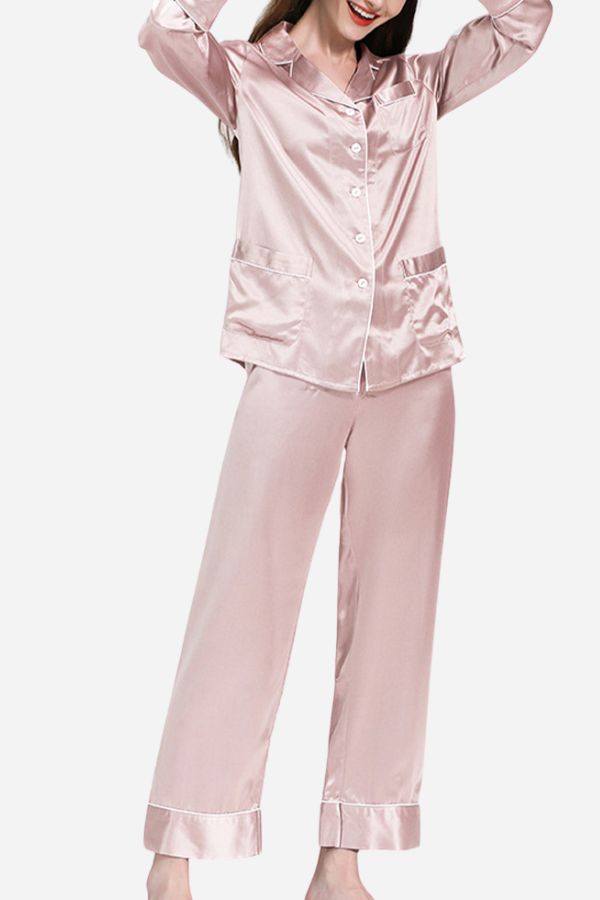 Woman wearing long sleeve button-up mulberry silk pajamas in light pink color