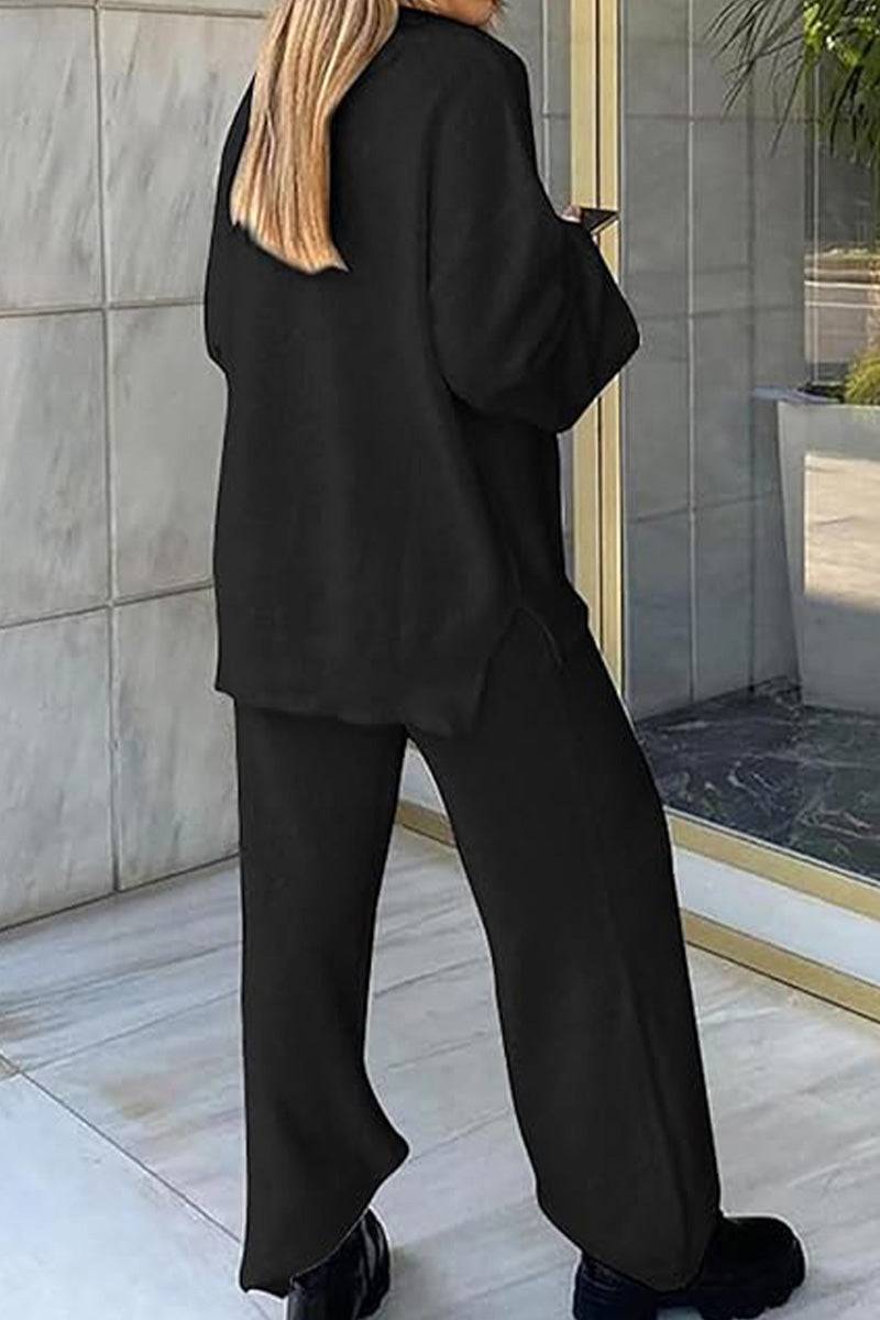 Woman wearing black Travel-Ease Two-Piece Set from behind, standing near glass door