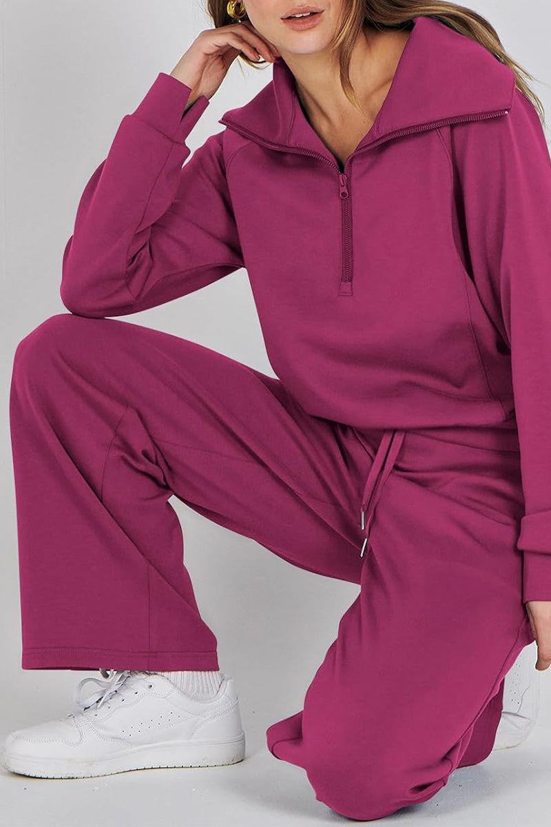 Woman wearing magenta loungewear buttersoft tracksuit set with zip-up top and drawstring pants, paired with white sneakers.
