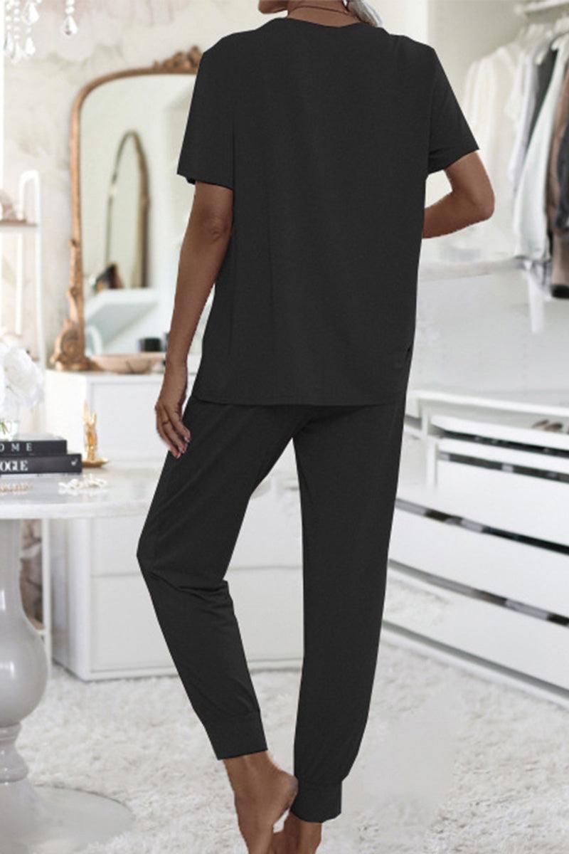 Woman wearing black ultra-soft two-piece loungewear set with short sleeves and jogger pants in modern indoor setting