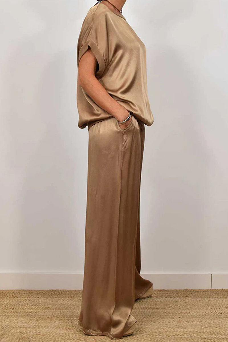Woman wearing a beige Silken Escape Satin Two-Piece Set with loose-fitting top and wide-leg pants.