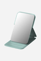 Compact travel pocket mirror with durable PU leather cover and clear glass surface in teal color