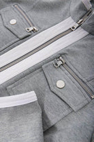 Close-up of grey Contrast Zip Two-Piece featuring contrasting white zipper and pockets with silver snap buttons.