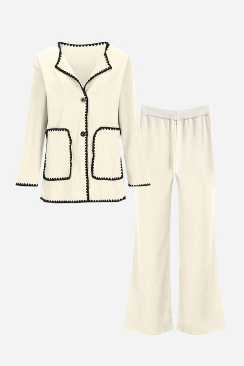 Cream knit cardigan and pants set with black contrast trim and pockets, soft comfortable fabric design.