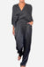 Woman wearing black Satin Wrap Lounge two-piece set with V-neck top and relaxed pants.