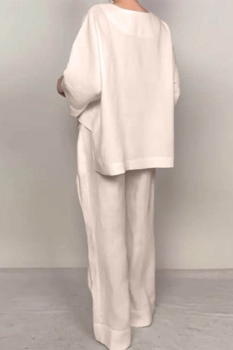 Back view of woman wearing Atelier Serenity Layered Two-Piece Set in neutral tones with relaxed wide-leg trousers and layered V-neck top.