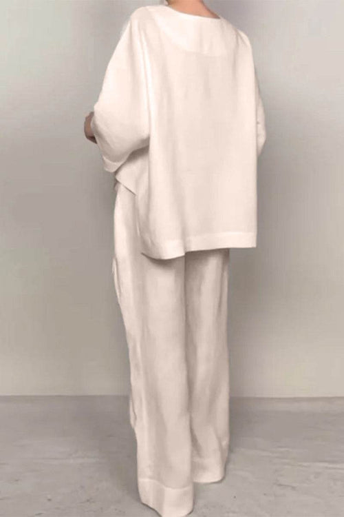 Back view of woman wearing Atelier Serenity Layered Two-Piece Set in neutral tones with relaxed wide-leg trousers and layered V-neck top.