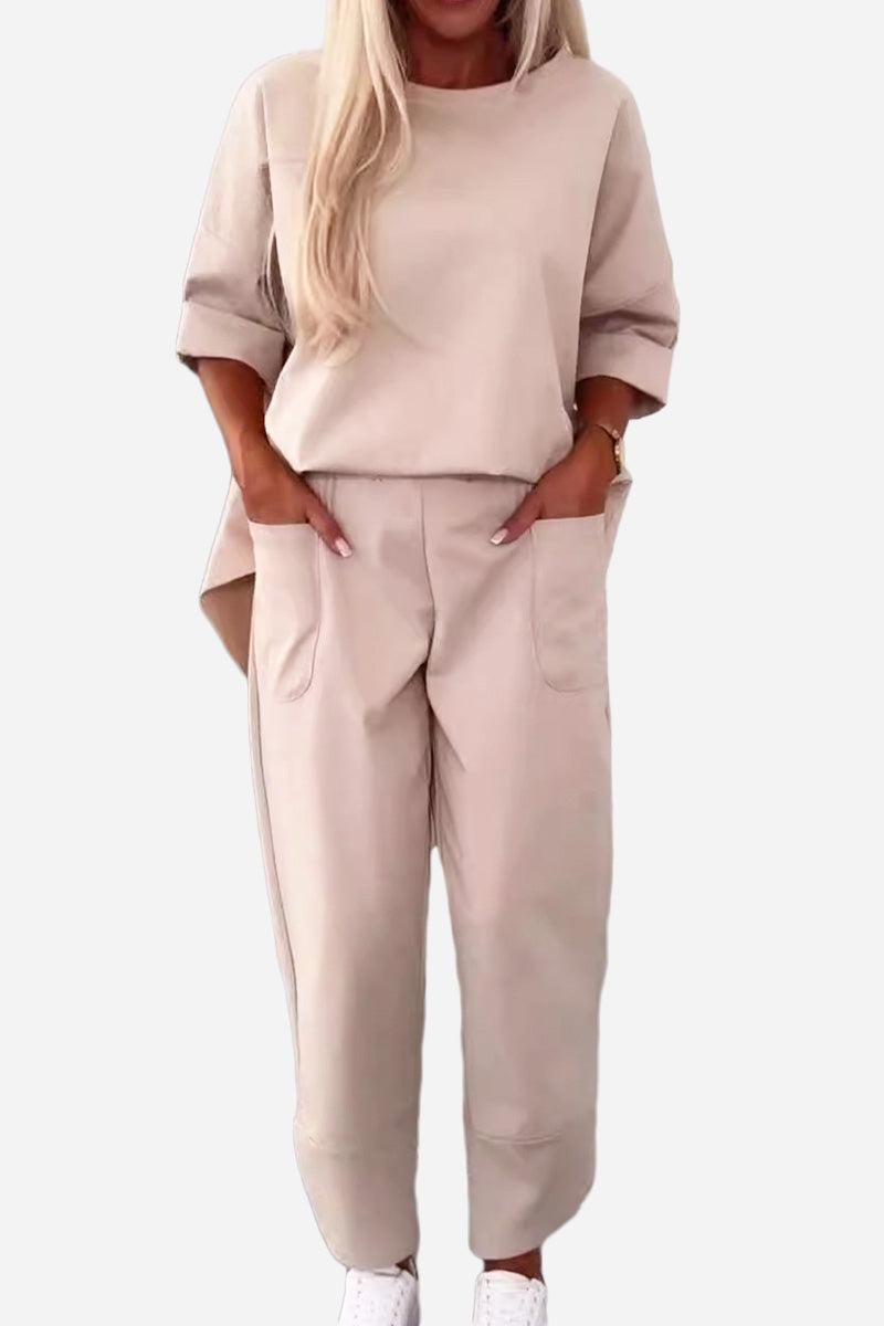 Beige minimalist two-piece set with a crew neck sweatshirt and matching jogger pants with side pockets for comfortable casual wear.