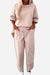 Beige minimalist two-piece set with a crew neck sweatshirt and matching jogger pants with side pockets for comfortable casual wear.