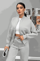 Woman wearing The Voyager Zip Set light grey zip-front sweatshirt and wide-leg joggers with pockets, stylish travel outfit