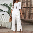 woman wearing white asymmetry flow co-ord with button-front top and flowing long pants, casual stylish outfit