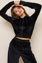 Black velour tracksuit with cropped hoodie and high-waist pants, soft and modern design