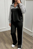 Woman wearing Colorblock Comfort Leisure Set with half-zip stand collar and wide-leg pants in black and gray color-block design.