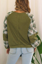 Back view of green waffle knit sweatshirt with green and white plaid brushed sleeves and relaxed fit on woman wearing light blue jeans