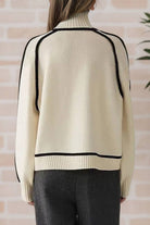 Back view of cream Zero Itch Turtleneck Sweater with black contrast trim and relaxed fit on model