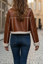 Women's cropped faux leather sherpa jacket with cream sherpa trim and full lining, styled with jeans.