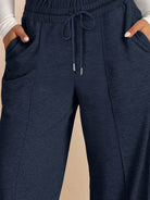 Soft knit wide-leg pants in breathable fabric with elastic drawstring waist and side pockets.