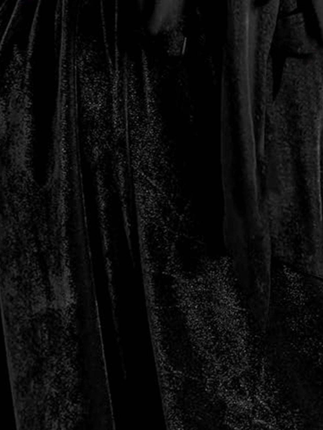 woman wearing a deep V-neck velvet suit with long sleeves and wide-leg pants