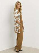 Woman wearing open-front three-piece co-ord with longline cardigan, tank top, and wide-leg trousers