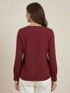 White pleated V-neck long-sleeve blouse with relaxed fit and button cuffs